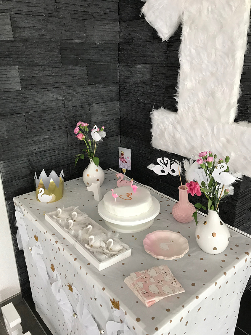 Das Märchentier Schwan bietet viel Anreiz für eine wunderschöne Geburtstagsdeko mit weißen Federn, Blumen und sanften Farben © eminecreative